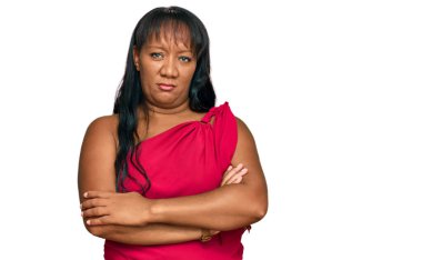 İspanyol orta yaşlı kadın gündelik giysiler giyiyor şüpheci ve gergin, yüzünde çapraz kollu tasvip etmeyen bir ifade var. negatif kişi. 