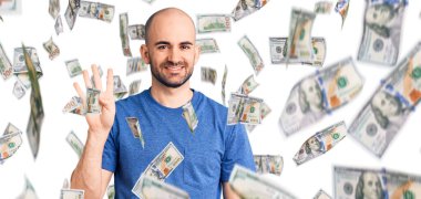 Gündelik tişört giyen genç yakışıklı dört numarayı gösterip işaret ederken kendinden emin ve mutlu bir şekilde gülümsüyor..