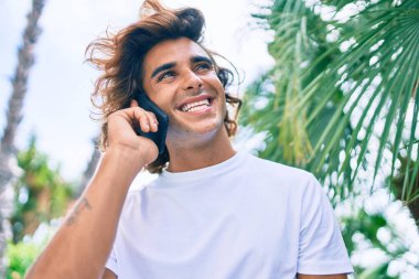 Genç İspanyol adam şehrin caddesinde akıllı telefondan konuşuyor.