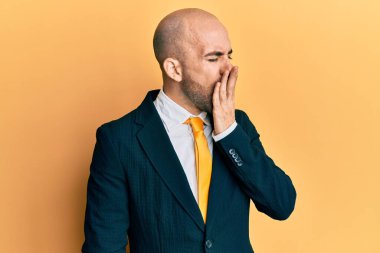 Genç İspanyol adam iş elbisesi ve kravat takmış. Elle ağzını kapatmaktan sıkılmış. Huzursuz ve uykulu.. 