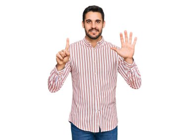 Genç İspanyol adam iş gömleği giyer ve altı numarayı göstererek gülümserken kendinden emin ve mutluydu.. 