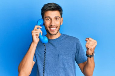 Bağrışarak, gururla bağıran, zaferi kutlayan, kollarını kaldırarak heyecanla bekleyen yakışıklı genç adam. 