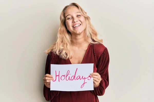 Menina Loira Jovem Segurando Feriados Banner Mensagem Sorrindo Rindo Duro — Fotografia de Stock