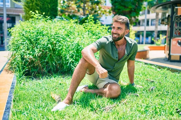 Joven Hombre Hispano Sonriendo Feliz Sentado Hierba Parque —  Fotos de Stock