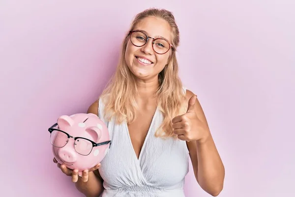 Ung Blond Flicka Håller Spargris Bank Med Glasögon Ler Glad — Stockfoto