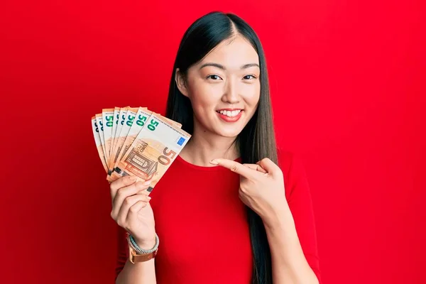 Mulher Chinesa Jovem Segurando Monte Notas Euro Sorrindo Feliz Apontando — Fotografia de Stock