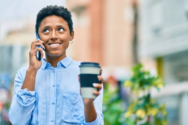 若いアフリカ系アメリカ人の女の子がスマートフォンで話して街でコーヒーを飲んで — ストック写真