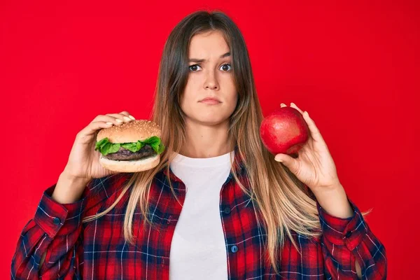 Bella Donna Caucasica Confrontando Hamburger Mela Rossa Sana Espressione Indiscussa — Foto Stock