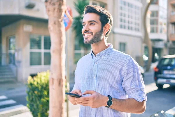 Молодий Іспаномовний Чоловік Посміхається Щасливим Використовуючи Смартфон Місті — стокове фото