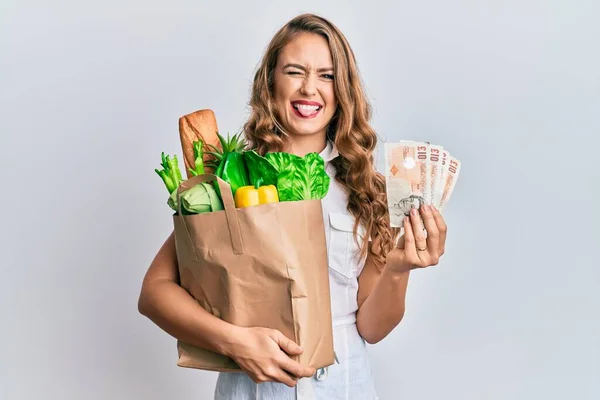 Ung Blond Flicka Som Håller Papperspåse Med Matvaror Och Pounds — Stockfoto