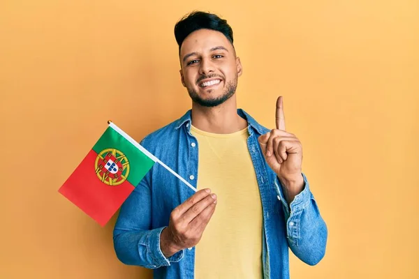 Mladý Arabský Muž Držící Portugalskou Vlajku Usmívající Nápadem Nebo Otázkou — Stock fotografie