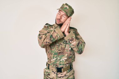 Kafkasyalı genç adam kamuflaj üniforması giyip uyuyordu. Yorgun düşler kurup, elleri ile poz verirken gözleri kapalıydı.. 