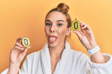 Bornoz giyen genç sarışın kadın elinde taze kivi, dilinde garip bir ifadeyle mutlu mesut dışarı çıkıyor.. 