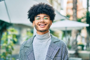 Genç Afrikalı Amerikalı iş adamı şehirde mutlu mesut dikiliyor..