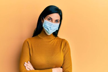 Yüzünde mutlu ve havalı bir gülümsemeyle tıbbi maske takan beyaz bir kadın. şanslı kişi. 