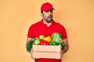 Yakışıklı, sakallı, üniformalı, yemek dağıtan, ağzı açık, şüpheci ve alaycı bakışlı bir adam. 