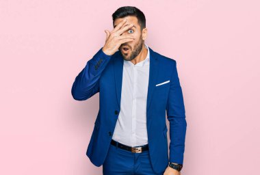 Genç İspanyol bir adam iş ceketi giyiyor. Şoka girmiş, yüzünü ve gözlerini kapamış, utangaç ifadesiyle parmaklarından bakıyor.. 