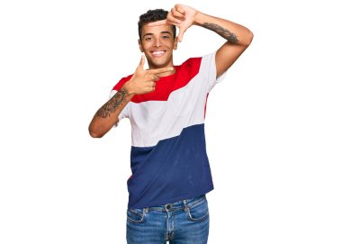 Genç, yakışıklı, Afro-Amerikalı sıradan kıyafetler giyen, gülümseyen, elleri ve parmakları gülen yüzlü bir adam. yaratıcılık ve fotoğrafçılık kavramı. 