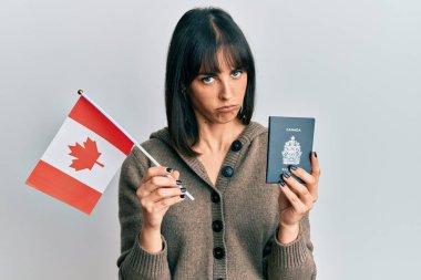 Elinde Kanada bayrağı ve pasaport taşıyan genç İspanyol kadın şüpheci ve gergin, sorun yüzünden surat asıyor. negatif kişi. 