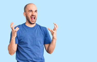 Genç, yakışıklı bir adam rahat tişört giyiyor. Deli gibi bağırıyor, agresif bir ifadeyle bağırıyor ve kollarını kaldırıyor. hüsran kavramı. 