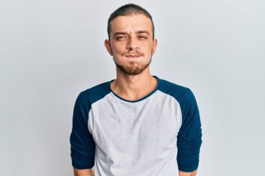 Günlük kıyafetler giyen İspanyol genç adam komik yüzlü yanakları şişiriyor. Havayla şişmiş ağız, çılgın bir ifade.. 