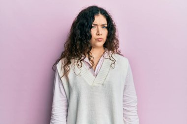 Kıvırcık saçlı, gündelik kıyafetler giyen, kuşkucu ve gergin genç esmer kadın, sorun yüzünden üzgün. negatif kişi. 