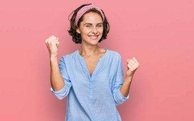 Gündelik kıyafetler giyen genç İspanyol kadın gururla bağırıyor, zaferi kutluyor ve kollarını kaldırıp başarıyı kutluyor. 