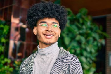Genç Afrikalı Amerikalı iş adamı şehirde mutlu mesut dikiliyor..
