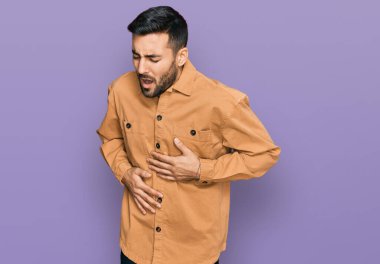 Mide bulantısı, acı verici bir hastalık yüzünden günlük giysiler giyen genç İspanyol bir adam. Ağrı kavramı. 