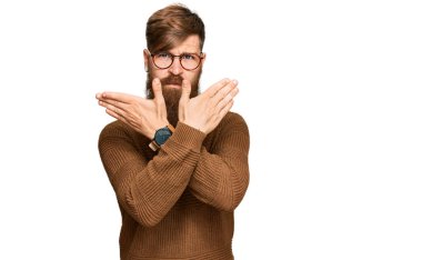 Genç İrlandalı kızıl elbiseli ve gözlüklü adam. Reddedilmiş yüz ifadesi. Kollarını kavuşturup negatif işaret veriyor. 