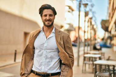 Genç İspanyol işadamı gülümseyerek şehirde mutlu mesut duruyor..