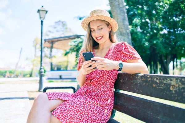Genç Sarışın Kadın Tatilde Parktaki Bankta Oturan Akıllı Telefonu Kullanıyor — Stok fotoğraf