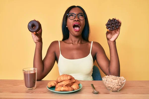 Młoda Afroamerykanka Trzymająca Czekoladowego Pączka Gofra Śniadanie Wściekła Wściekła Krzycząca — Zdjęcie stockowe