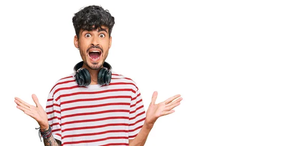 Joven Hombre Hispano Escuchando Música Usando Auriculares Celebrando Loco Sorprendido — Foto de Stock