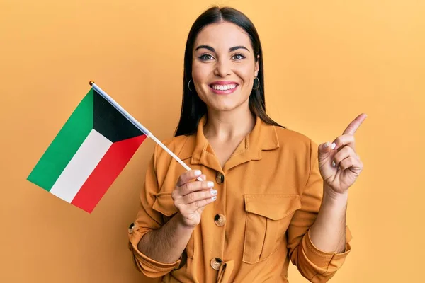 Jovem Morena Segurando Bandeira Kuwait Sorrindo Feliz Apontando Com Mão — Fotografia de Stock