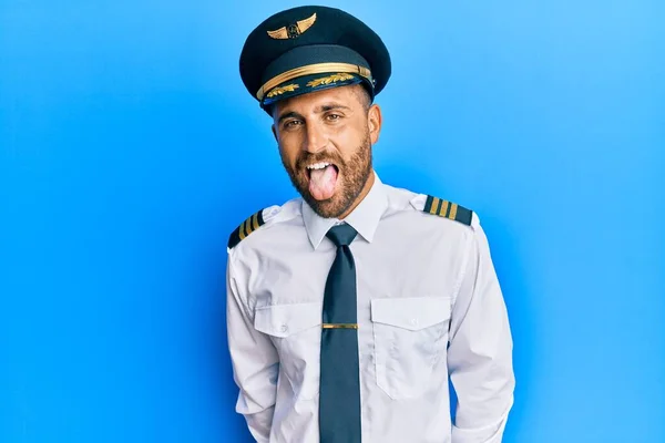Pohledný Muž Plnovousem Uniformě Pilota Letadla Vystrkující Jazyk Veselým Výrazem — Stock fotografie