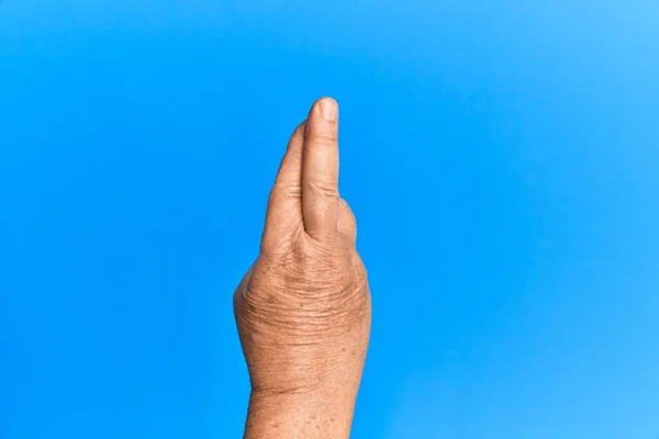 Mão Homem Hispânico Sênior Sobre Fundo Isolado Azul Gesticulando Dedos — Fotografia de Stock