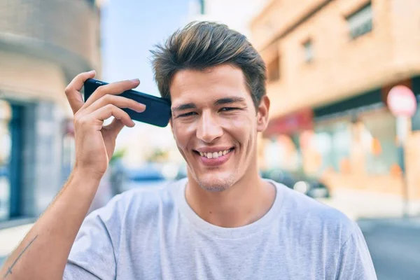 Joven Hombre Caucásico Sonriendo Feliz Escuchando Mensaje Audio Utilizando Teléfono —  Fotos de Stock