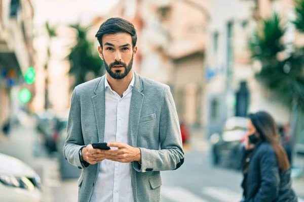 Jonge Spaanse Zakenman Met Serieuze Expressie Met Smartphone Stad — Stockfoto