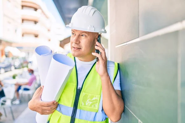 Architekt Mittleren Alters Spricht Auf Dem Smartphone Und Hält Baupläne — Stockfoto