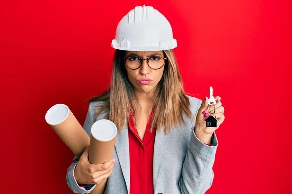 Mooie Brunette Vrouw Draagt Een Veiligheidshelm Met Blauwdrukken Sceptisch Nerveus — Stockfoto