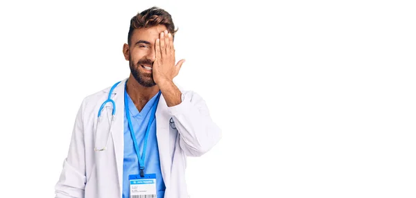 Joven Hispano Vistiendo Uniforme Médico Estetoscopio Cubriendo Ojo Con Mano —  Fotos de Stock