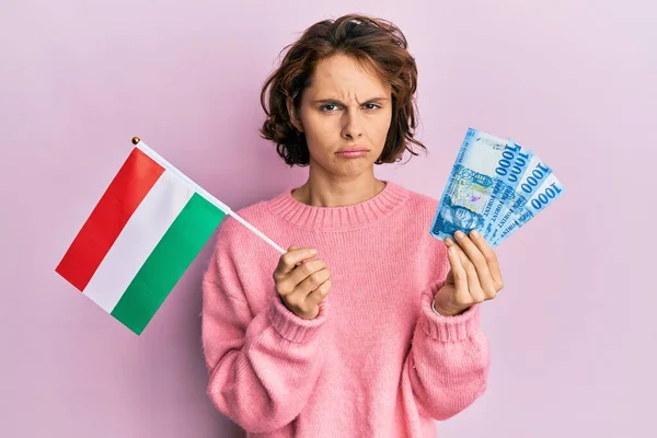 Młoda Brunetka Trzymająca Węgierską Flagę Forinty Banknotów Przygnębiona Martwiąca Się — Zdjęcie stockowe