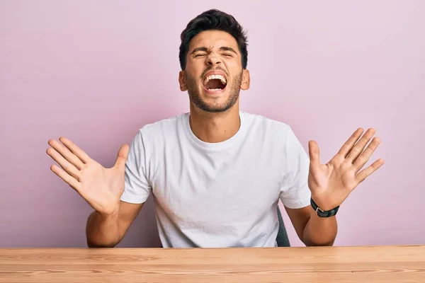 Joven Hombre Guapo Con Camiseta Blanca Casual Sentado Mesa Celebrando —  Fotos de Stock