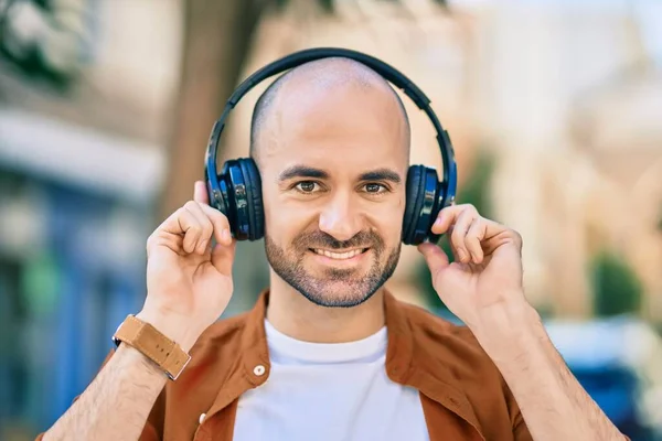 Νεαρός Ισπανός Φαλακρός Άντρας Χαμογελάει Χαρούμενος Ακουστικά Στην Πόλη — Φωτογραφία Αρχείου