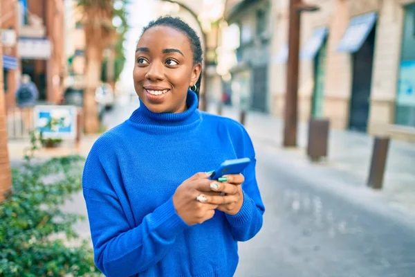 Νεαρή Αφροαμερικανή Γυναίκα Χαμογελά Ευτυχισμένη Χρησιμοποιώντας Smartphone Στην Πόλη — Φωτογραφία Αρχείου