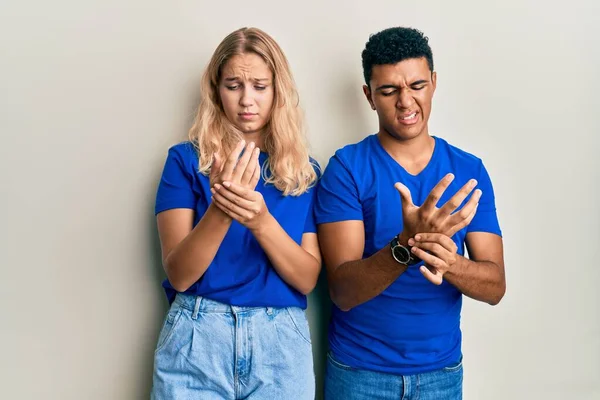 年轻的跨种族夫妇穿着休闲装 手指头疼痛 关节炎发炎 — 图库照片