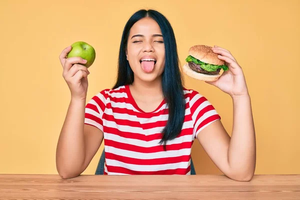 Joven Asiática Chica Comparando Hamburguesa Saludable Manzana Pegando Lengua Fuera —  Fotos de Stock