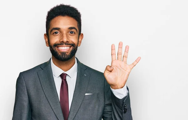 自信を持って幸せな笑顔ながら 若いアフリカ系アメリカ人の男性は ビジネス服を着て指の数4で示すと指摘します — ストック写真