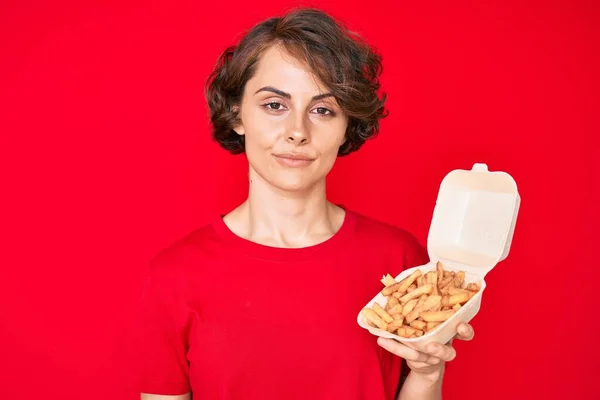 Ung Latinamerikansk Kvinna Håller Potato Chip Tänkande Attityd Och Nykter — Stockfoto